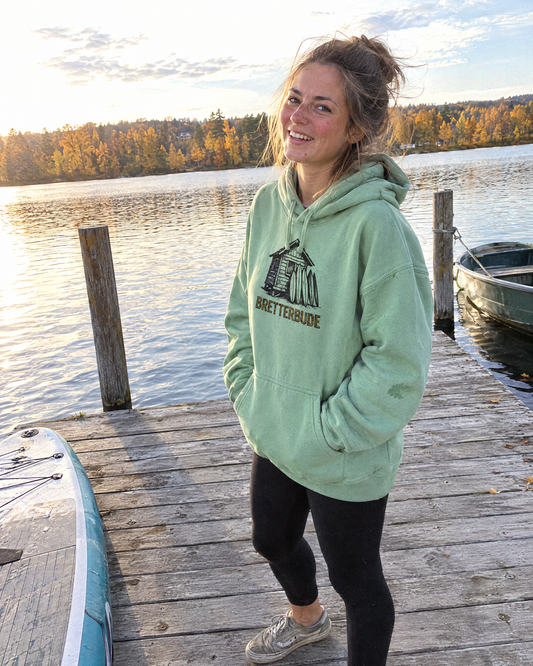 Achtung Bretterbude Organic Oversize Hoodie in Misty Jade getragen auf einem Holzsteg am See im Herbst
