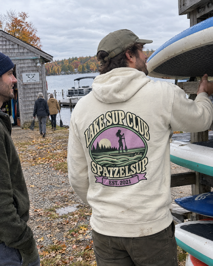 Mann im Lake SUP Club Hoodie in Bone nimmt SUP-Board vom Rack